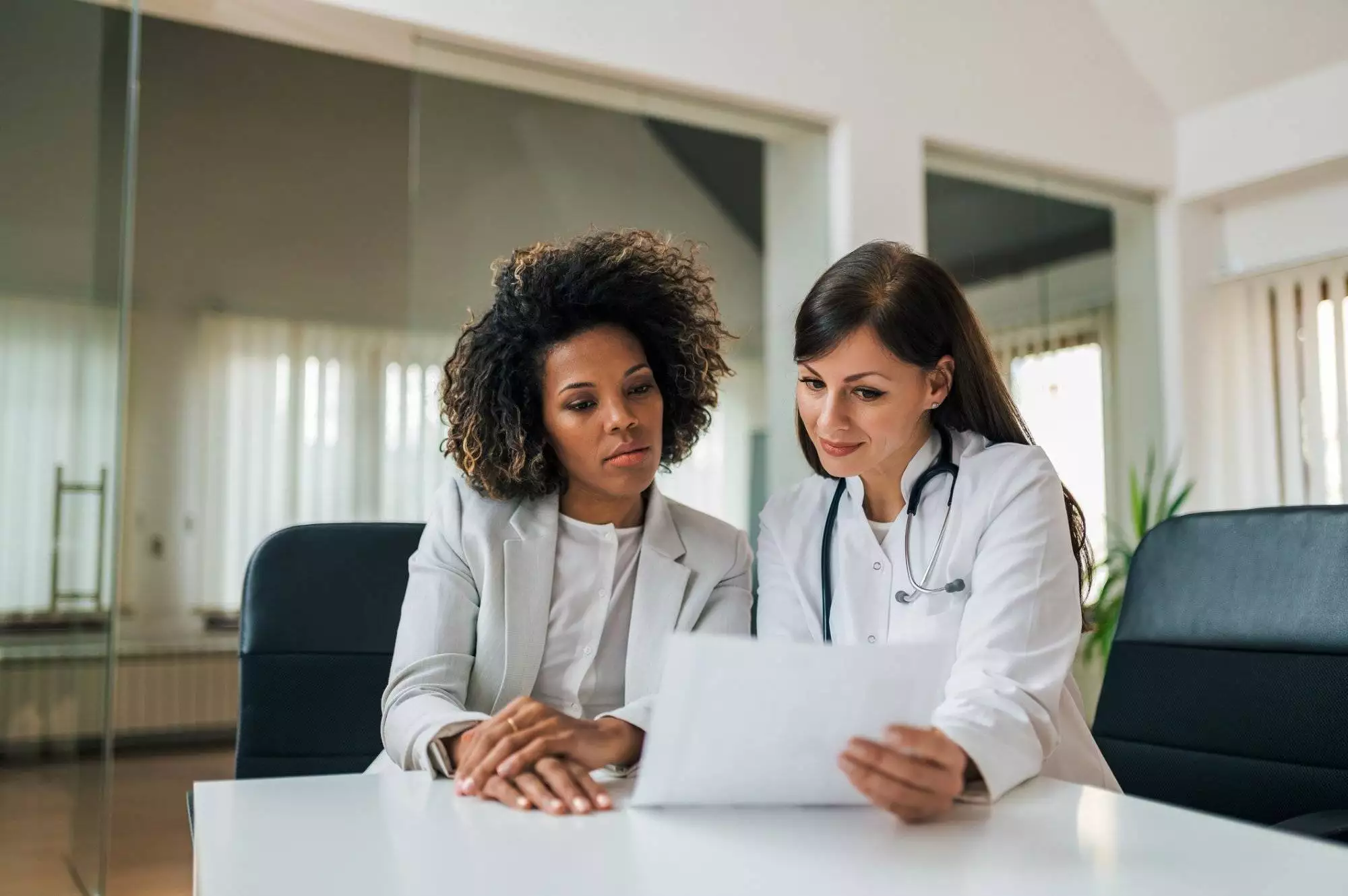 General practitioner showing test results to a charming mixed race woman.